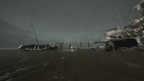 Old Wooden Pier with Boats at Low Tide Under a Gloomy Sky
