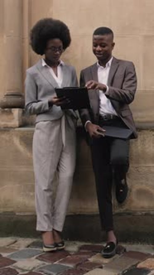 Colleagues Dressed in Business Attire Looking at a Tablet