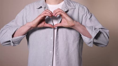 Man Making Heart Gesture with Hands in Studio