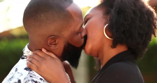 Loving Couple Sharing Tender Kiss Outside in Sunlight