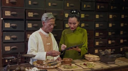 Un père âgé enseigne à sa fille les bases de la phytothérapie chinoise