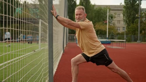 Elderly Caucasian Man Pensioner Athlete Outside City Stadium Physical Activity Sport Flexibility