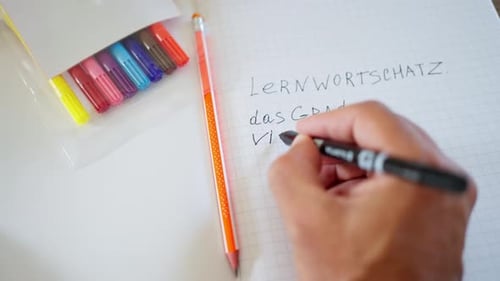 Hand with Pen A Focused Student Writes Detailed Notes in a Wellorganized Notebook Using a Pencil