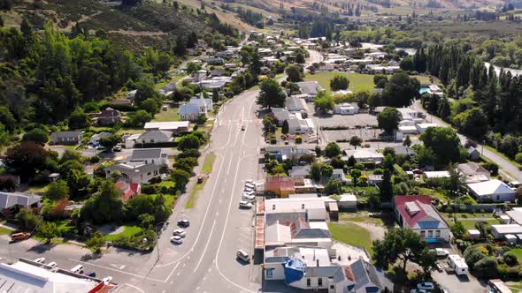 Main road in Roxburgh, New Zealand. Aerial fly backward over the small ...