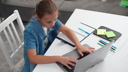Young Girl Uses Laptop for Education at Home