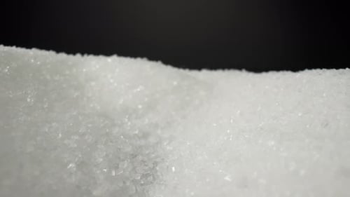 Camera focuses in on a mound of white sugar, Macro video