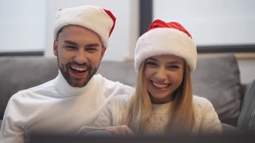 Couple in Santa Hats Video Chatting at Home