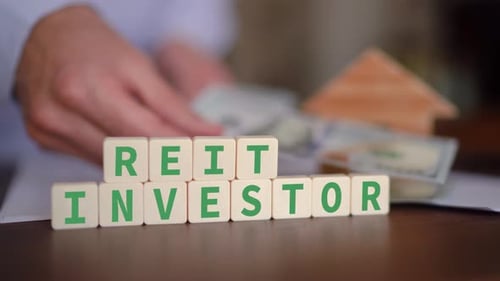 Concept of investing in a REIT fund with cash. Selective focus with man counting money in the backgr