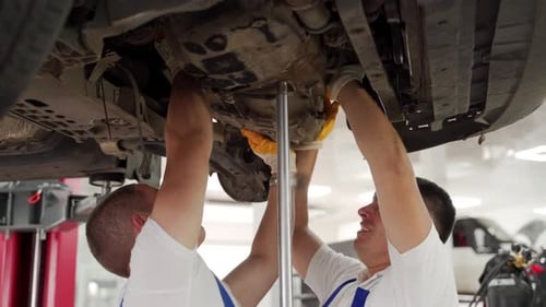 Auto Mechanics Teamwork Removing Car Gearbox in Garage Vehicle Maintenance Technicians Disassemble