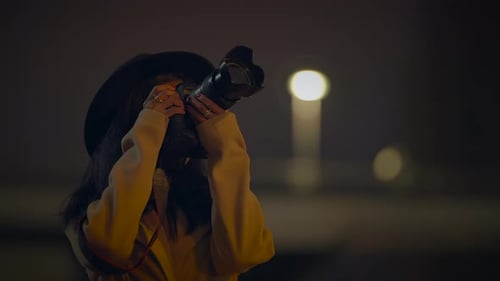 Young Woman Takes Photos Outside at Night