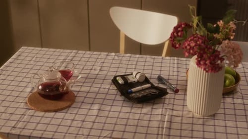 Diabetes Medical Supplies on Table with Tea and Flowers