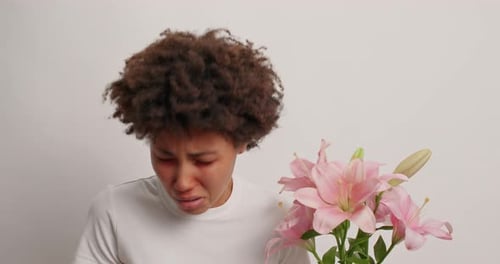 Woman with Allergies holding Flowers inside Studio