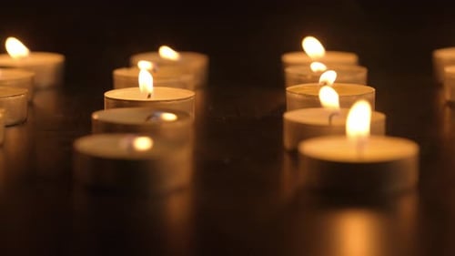 Burning Candles Flickering in the Dark