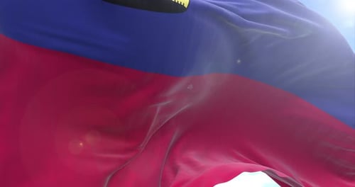 Realistic Liechtenstein Flag Waving in Wind Against Blue Sky