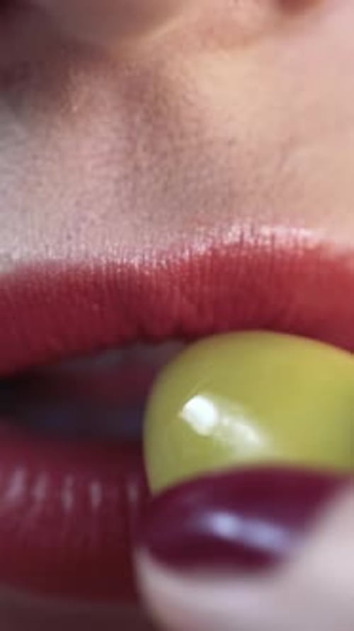 Gros plan des lèvres rouges sexy d'une femme mordant une olive verte Action Lèvres rouges sensibles, très gros plan