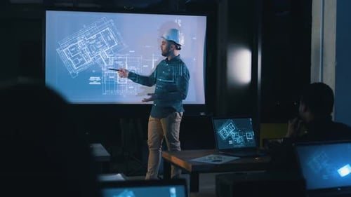 Architect showing plan of building. Male leader talking to employees, showing the plan.