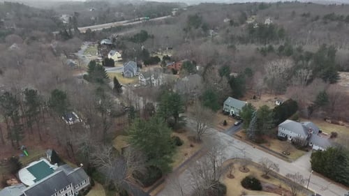 Cold winter day in rural suburb neighborhood of Massachusetts, America. Aerial wide shot.