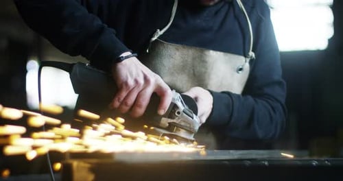 Worker Grinding Metal with Flying Sparks Close Up
