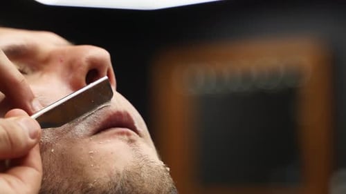 Man Receiving Professional Shave at the Barber Shop