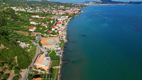 Coastal town with colorful buildings by a calm sea and a winding road along the shoreline