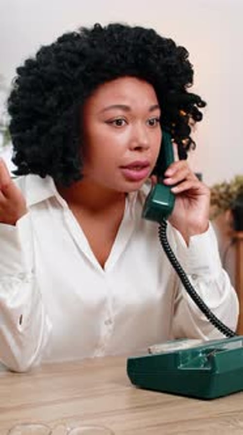 Woman Answering Old Telephone at Desk