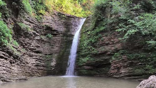 A Beautiful Little Waterfall Slowly Flows Down From the Mountains Into the Lake