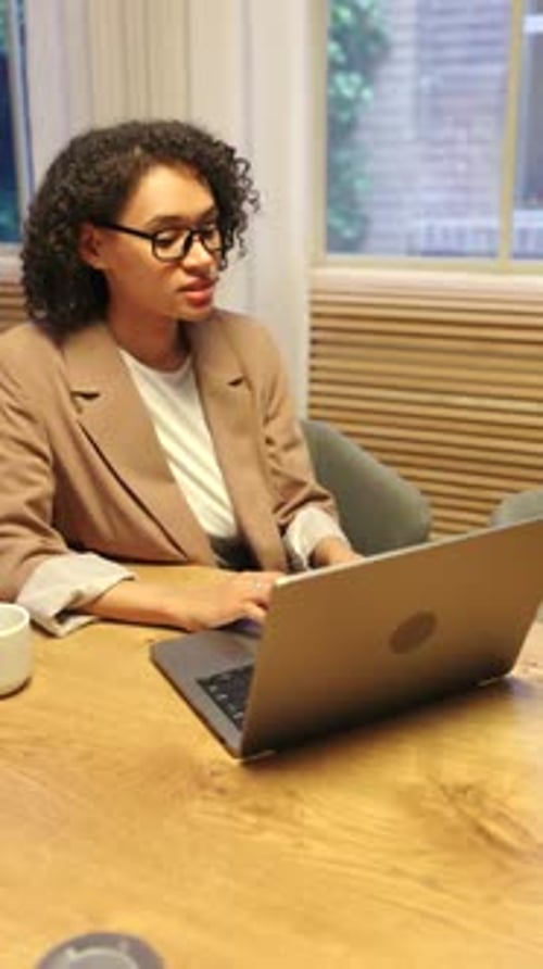 Business Woman Working on Laptop in Bright Modern Office with Natural Daylight Inside