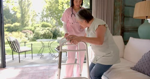 Helping senior asian woman with walker, nurse providing physical therapy at home