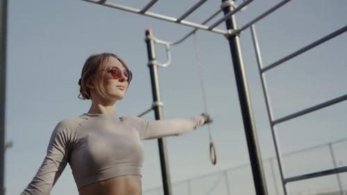 Young Woman Stretching Outdoors on Sunny Day
