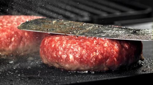 Close Up of Raw Burger Patties Cooking on Grill