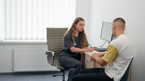 in a Modern Clinic in a Small Therapist s Office a Young Girl Doctor with a Stethoscope Conducts an