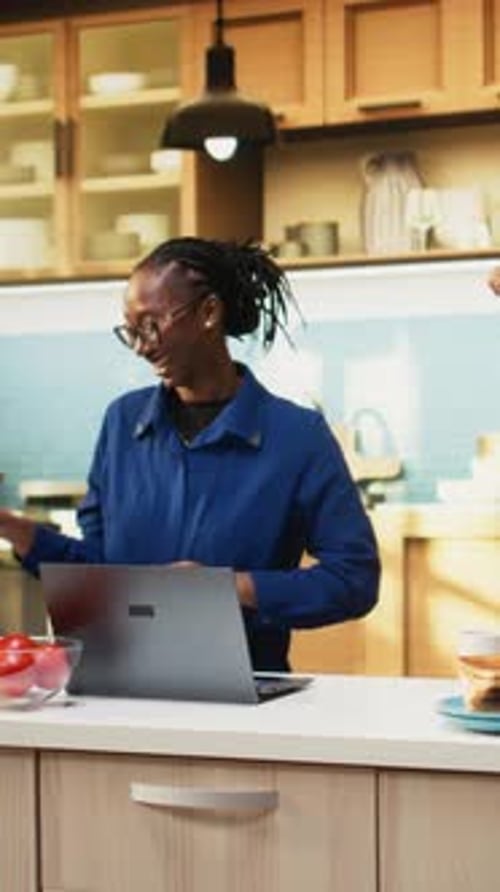 Woman Singing and Dancing in Kitchen with Laptop