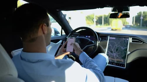 Successful Businessman Browsing Modern Smartphone While Riding an Autonomous Self Driving Electric