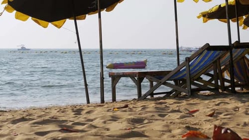 Wooden Sun Beds with Umbrella on a Sandy Beach Against the Sea Thailand Pattaya
