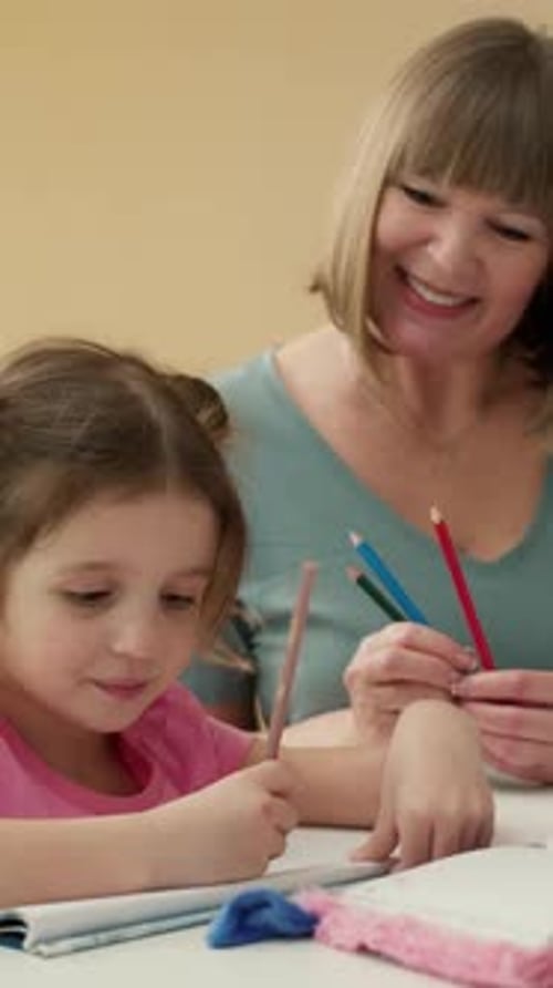 Happy Mature Woman Drawing with Pencils Together with Her Little Granddaughter