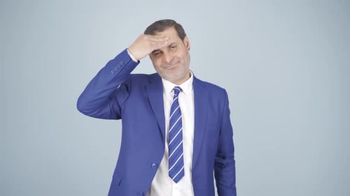Man in Blue Suit Massages Forehead