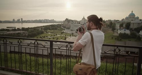 Male Photographer Taking Photo of City During Journey