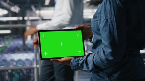 Data Center Admin Checking Code on Tablet Next to Colleague