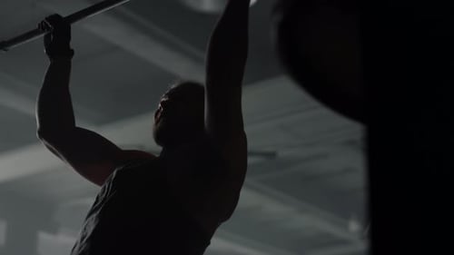 Strong Man Pull-up Workout in Dark Gym