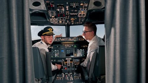 Portrait of smiling young captains of airplane pilots in uniform preparing for flight in simulator