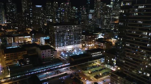 Aerial - Subway Train on Elevated Track with City Skyline in Background