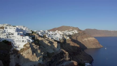 Aerial: Flying Over City Of Oia On Santorini Greece during sunset
