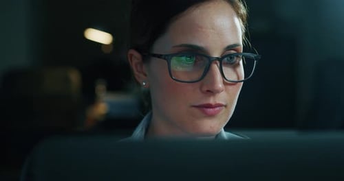 Zeitlupe einer jungen schönen Geschäftsfrau mit Brille, die in einem Büro mit einem Computer arbeitet