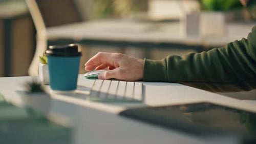 Männliche Hand mit Computermaus bei der Arbeit im Zimmer, Nahaufnahme, Webdesigner an der Tastatur