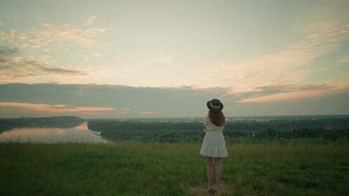 Woman in White Dress Reflecting By Lake at Sunset