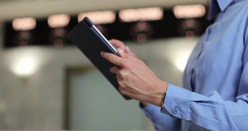 Close Up of Unrecognizable Hotel Worker Wearing Uniform Standing in Lobby or Lounge Using Digital