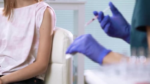 Girl Receives Vaccine from Medical Professional in Hospital