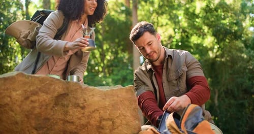 Couple, kettle and backpack with hiking in forest with helping hand, bonding or vacation in summer