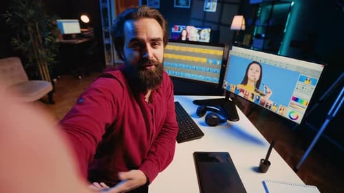 Man Video Editor Explaining Process Indoors at Desk
