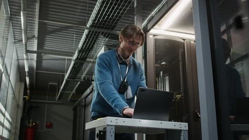 Data Center Technician Using Walkie Talkie and Laptop during Server Maintenance